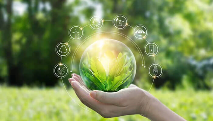 Hand holding a sustainable business model symbol with green energy icons representing eco-friendly practices in a business environment.