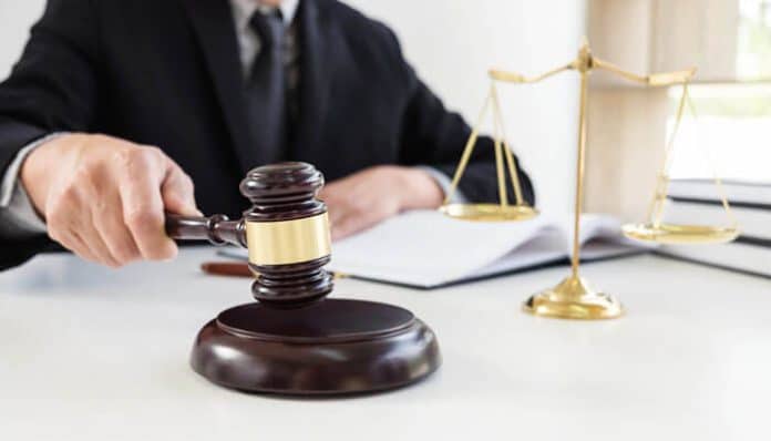 Judge using gavel with legal scales on desk, symbolizing courtroom justice and the impact of Dropped Criminal Charges on reputation and legal outcomes.
