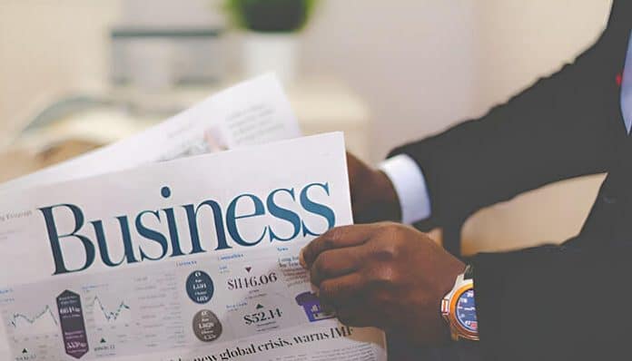 A professional person reading a business newspaper, representing decision-making and management principles in Corporate Governance.
