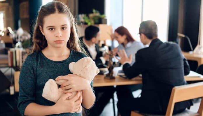 A young girl holding a teddy bear looks sad as her parents argue with a lawyer in the background, symbolizing the emotional impact of Family Law cases.