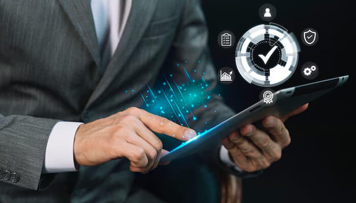 Business professional interacting with a tablet displaying digital icons and data streams, representing the modernization and optimization of legacy apps in business environments.