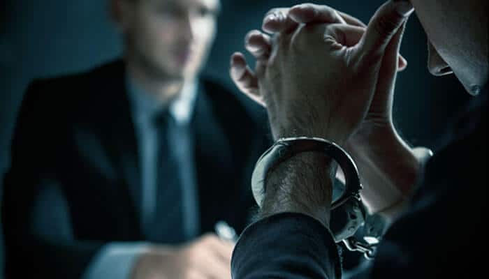 Man in handcuffs during police questioning, symbolizing a DUI arrest and the need for legal defense.