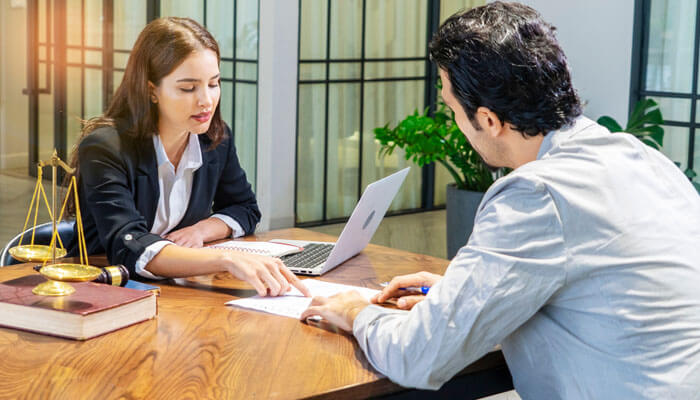 Lawyer consulting a business client on strategies to protect businesses against fraud.