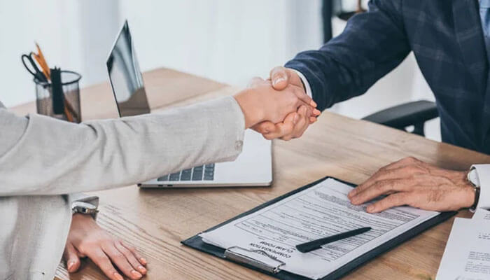 Client shaking hands with attorney after signing legal documents, showing how the lawyer you choose can shape your case results.