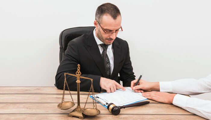Personal Injury Attorney reviewing documents with a client, with a gavel and scales of justice on the table, symbolizing legal consultation and services