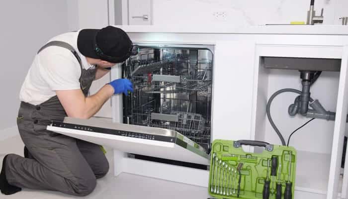 Contractor installing a dishwasher linked to the No Demo Reno lawsuit, highlighting faulty installation claims and renovation safety issues.