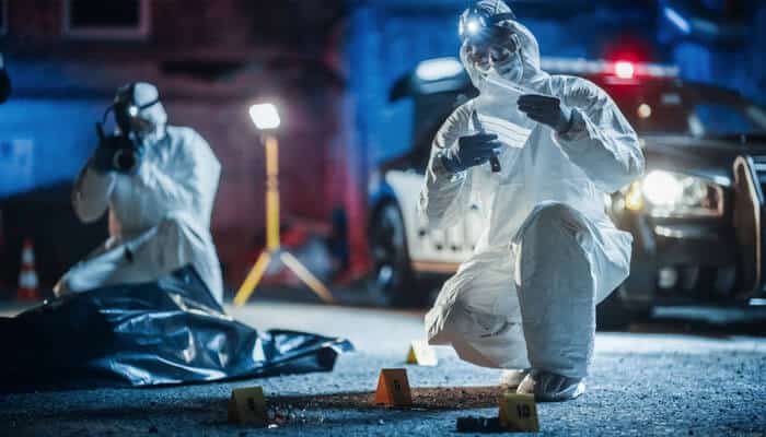 Forensic investigators examining a scene with evidence markers and police lights, symbolizing the investigation process in a serious Slip and Fall Accident case.