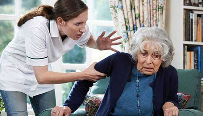 A caregiver aggressively grabs an elderly woman’s arm, depicting possible mistreatment in a nursing facility—highlighting the need for a Nursing Home Abuse Lawyer in Albuquerque.