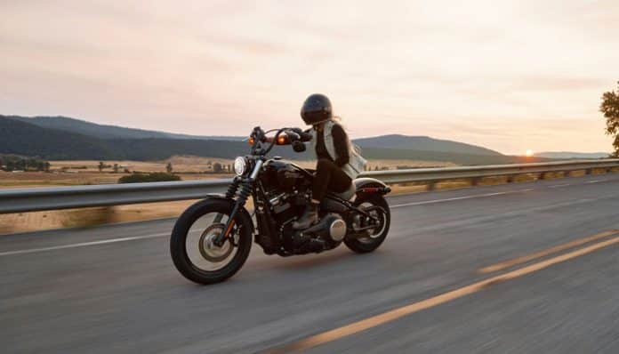 A motorcyclist rides safely on an open highway at sunset, symbolizing awareness of Motorcycle Laws and responsible riding across U.S. states.