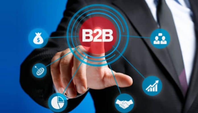 A professional marketer in a suit pointing to a virtual B2B network interface showing icons for growth, strategy, and partnerships — representing a modern B2B Marketing Agency driving business success.