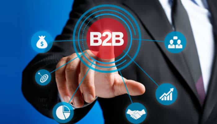 A professional marketer in a suit pointing to a virtual B2B network interface showing icons for growth, strategy, and partnerships — representing a modern B2B Marketing Agency driving business success.