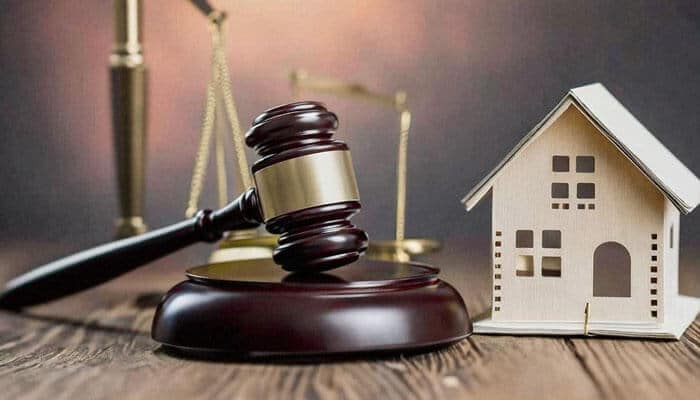 Gavel and wooden house model symbolizing the No Demo Reno lawsuit, highlighting home renovation legal issues and disputes involving HGTV’s show.