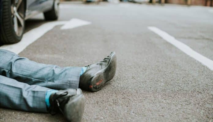 A pedestrian lying injured on the road after being hit by a car, symbolizing the importance of understanding Pedestrian Accident Laws in New York for legal protection and compensation.