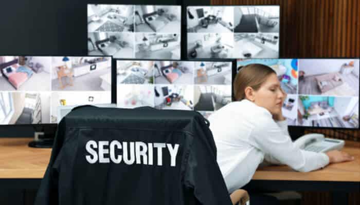 When Negligent Security Causes Serious Injuries- Myleagalopinion A security guard asleep at a control desk with multiple surveillance screens displaying camera footage — symbolizing negligent security and lack of proper monitoring at a property or event.