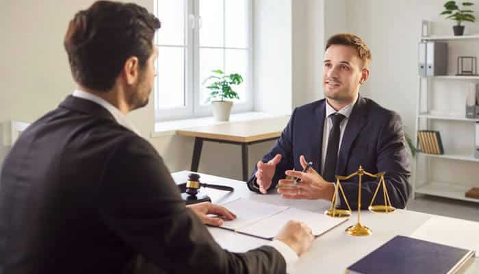 commercial injury Lawyers discussing a with a client in an office, with legal documents and justice scales on the table. 