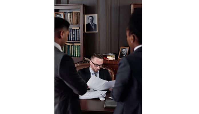 Lawyer reviewing documents at a desk with a professional briefcase for lawyers, illustrating courtroom and office readiness.