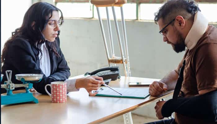 Case Evaluation and Investigation - Mylewaglopinion - My Legal Opinion A client with injuries consulting Personal Injury Lawyers at a desk, reviewing documents and discussing legal options after an accident.