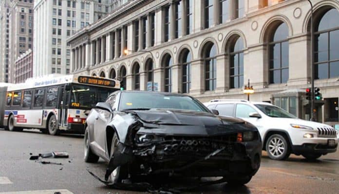 A damaged car on a busy city street after a collision, highlighting the need for Car Accident Compensation and legal support.