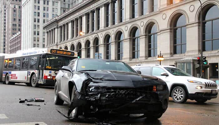 A damaged car on a busy city street after a collision, highlighting the need for Car Accident Compensation and legal support.