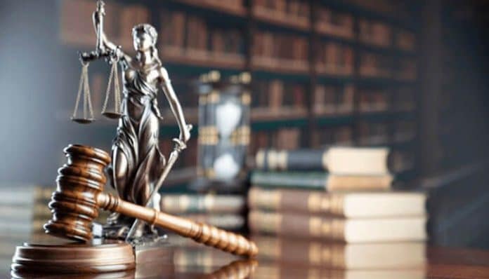 A gavel and lady justice statue in a law office, symbolizing the role of lemon lawyers in determining whether a car qualifies for a claim under lemon law.