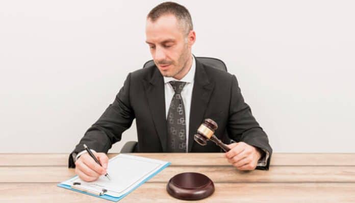 A personal injury lawyer reviewing legal documents at a desk while preparing a client’s case for compensation.