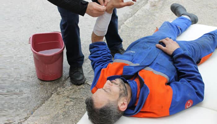 A worker injured on the job receiving medical assistance — a real example of a workplace injury that may qualify for compensation claims.