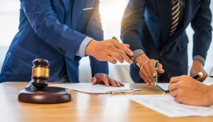 Lawyers reviewing documents and signing papers as part of legal reforms under the Draft Wills Bill 2025