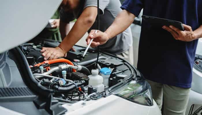 Reviewing Repair Attempts - Myleagalopinion - My Legal Opinion Mechanics inspecting a car engine, highlighting the role of lemon lawyers in reviewing repair attempts and defects when determining if a car qualifies for a lemon law claim.