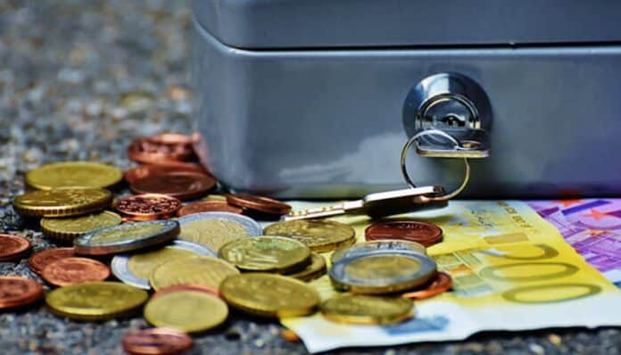 A close-up image of coins and currency beside a locked cash box, symbolizing smart money management and financial discipline — representing Smart Business Leaders on Personal Saving Habits.
