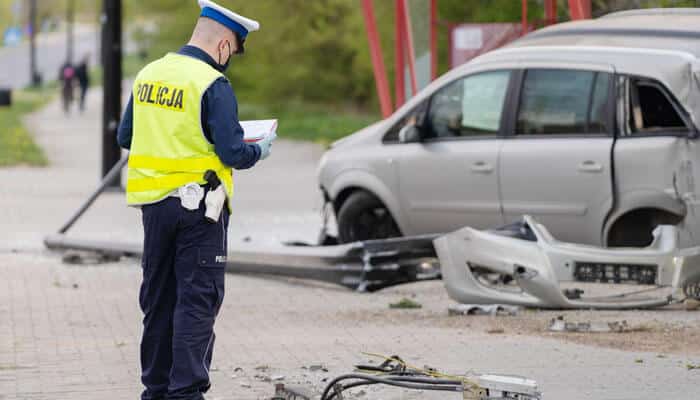 A police officer inspects the scene of a commercial vehicle accidents, documenting the damage and securing evidence for the investigation.