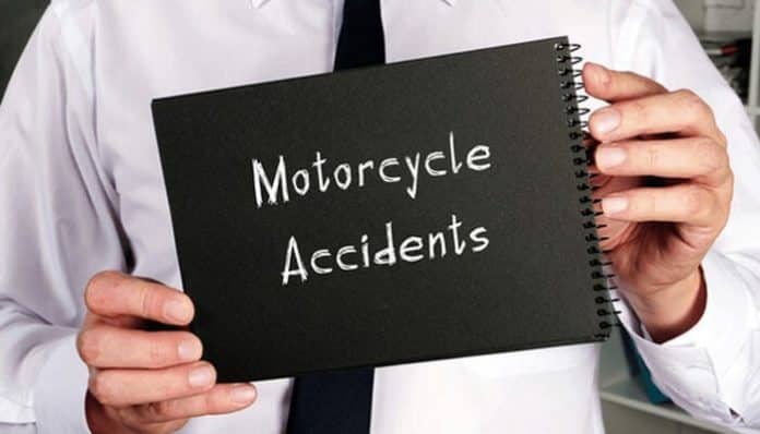 A person holding a black notebook labeled Motorcycle Accidents, representing legal guidance and support from motorcycle accident lawyers.