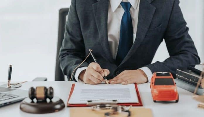 Alt Text: Car accident lawyer reviewing documents in an office, emphasizing the importance of experience and legal expertise in handling car accident claims and securing settlements.