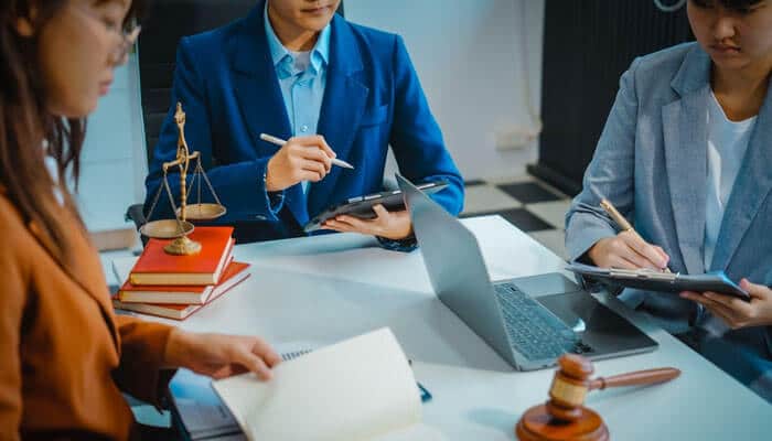 Legal team discussing paperwork and strategies for a wrongful death claim, with law books and a gavel in the background, representing legal counsel in wrongful death cases.