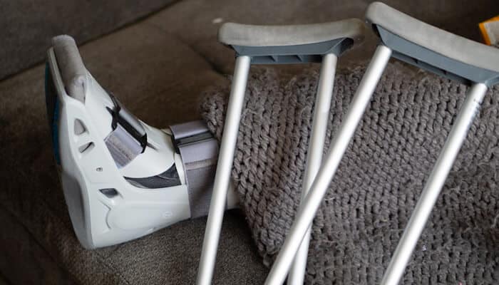 Workplace slip-and-fall accident injury with crutches and foot brace.