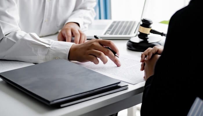 Attorney Lawrence Kajy consulting with a client and reviewing legal documents for a Michigan personal injury case.