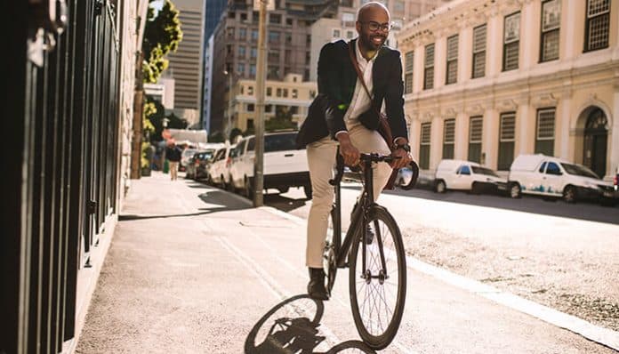 Businessman cycling through the city, highlighting the importance of understanding bicycle laws for urban cycling
