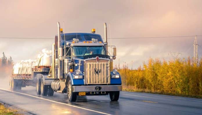 Large truck driving on the road, showcasing a typical truck accident scene in the background.