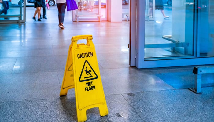 How Liability Is Determined in Complex Cases - My Legal Opinion - My Legal Opinion Wet floor caution sign in a public building showing how slip-and-fall incidents can lead to multiple-party personal injury cases involving property owners and maintenance teams.