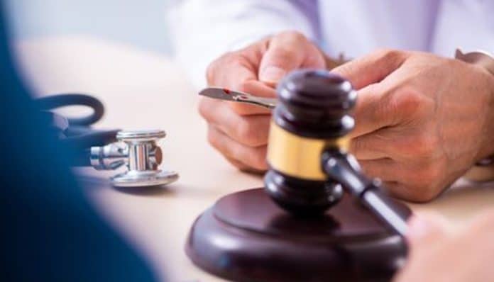 Michael Johnson Legal: A close-up of a legal document and gavel with a stethoscope, symbolizing expert physician contract review and negotiation services.