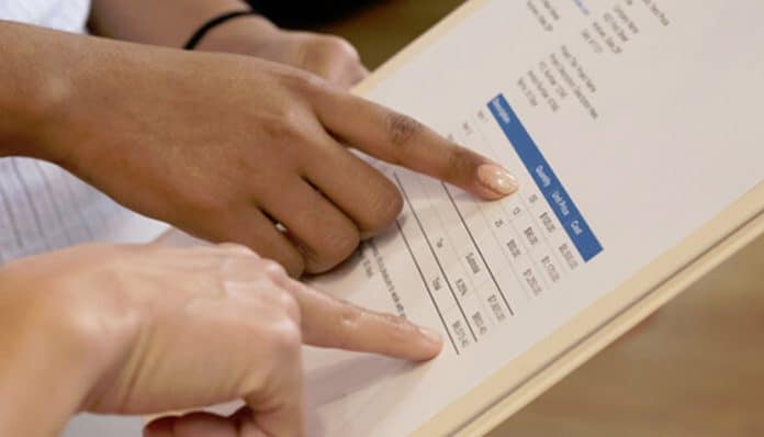 Close-up of hands pointing at a sound contractor invoice with detailed line items and payment information.