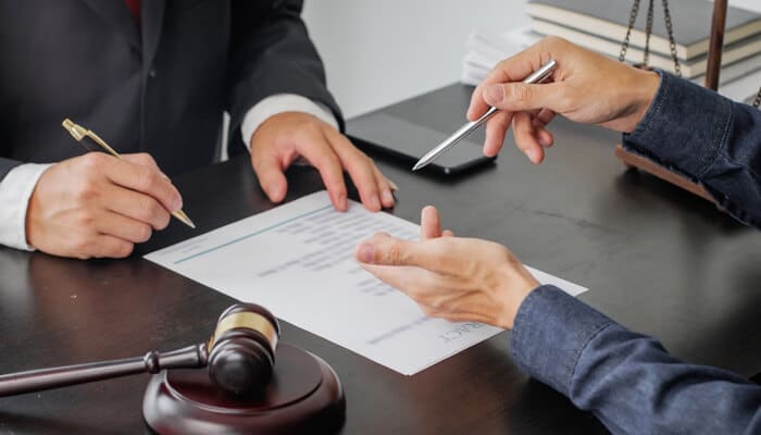 How to review your VLex presence - Myleagalopinion - My Legal Opinion A lawyer and client reviewing legal documents related to VLex court records, with a gavel on the desk.