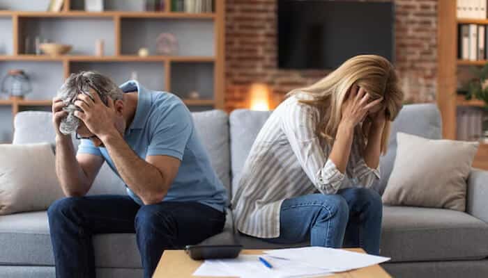 Managing the Emotional Side of the Process - My Legal Opinion - My Legal Opinion Stressed couple sitting on a couch, showing the emotional need for legal guidance in modern divorce cases.