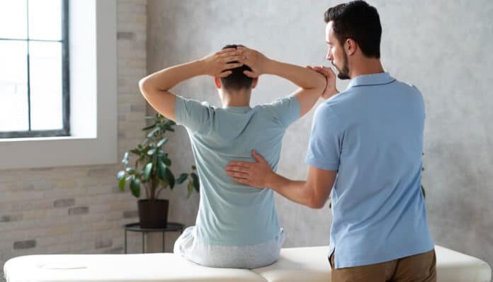 Physical therapist guiding a patient through spinal support exercises as part of physical therapy for sciatica recovery after injury