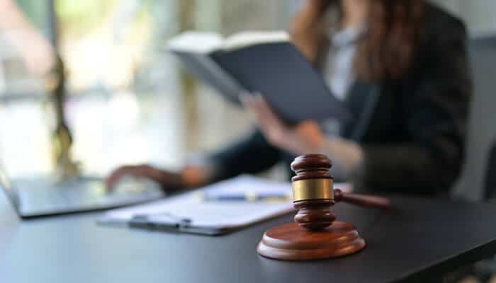 Standout legal career representation with a courtroom gavel and legal professional reviewing documents in a modern office