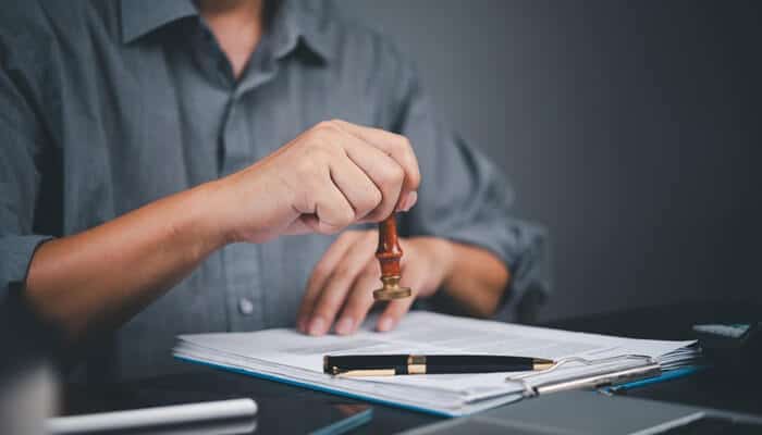 Skipping Signatures or Notarization - Myleagalopinion - My Legal Opinion A person stamping a legal document with a seal, symbolizing the finalization and notarization process in drafting an affidavit.