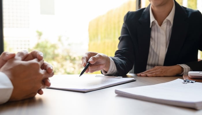 Support With Insurance Companies - Myleagalopinion - My Legal Opinion A lawyer from Maze Law Offices discussing legal documents with a client, offering expert legal assistance.