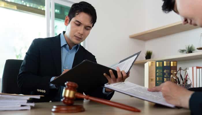 Lawyer reviewing documents related to a sound contractor invoice, emphasizing legal and professional aspects of payment agreements.