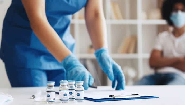 Early Stage Clinical Trials scene with healthcare staff preparing trial documents and vaccine vials before participant enrollment