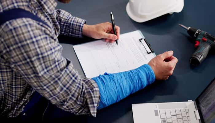 Injured construction worker completing claim paperwork with guidance from Workers' Compensation Lawyers.