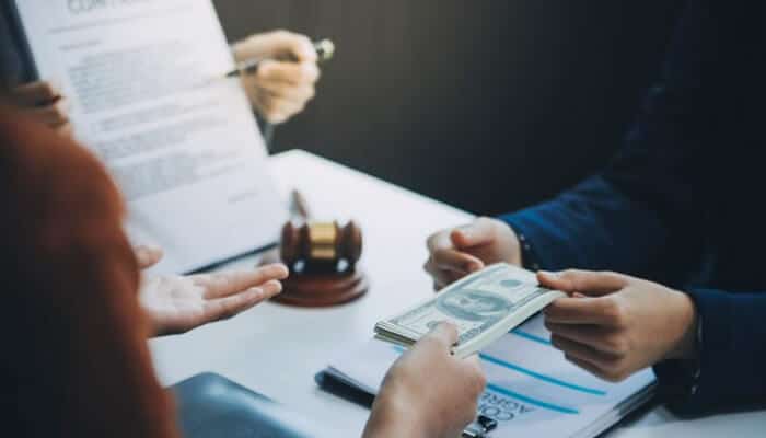 What Compensation Can Look Like When You Have the Right Lawyer - My Legal Opinion - My Legal Opinion Client handing payment to a premises liability lawyer during a legal consultation.